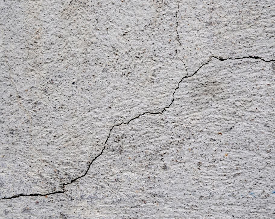 Why do hairline cracks appear in concrete